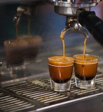 Una máquina de café que vierte líquido en vasos de chupito.